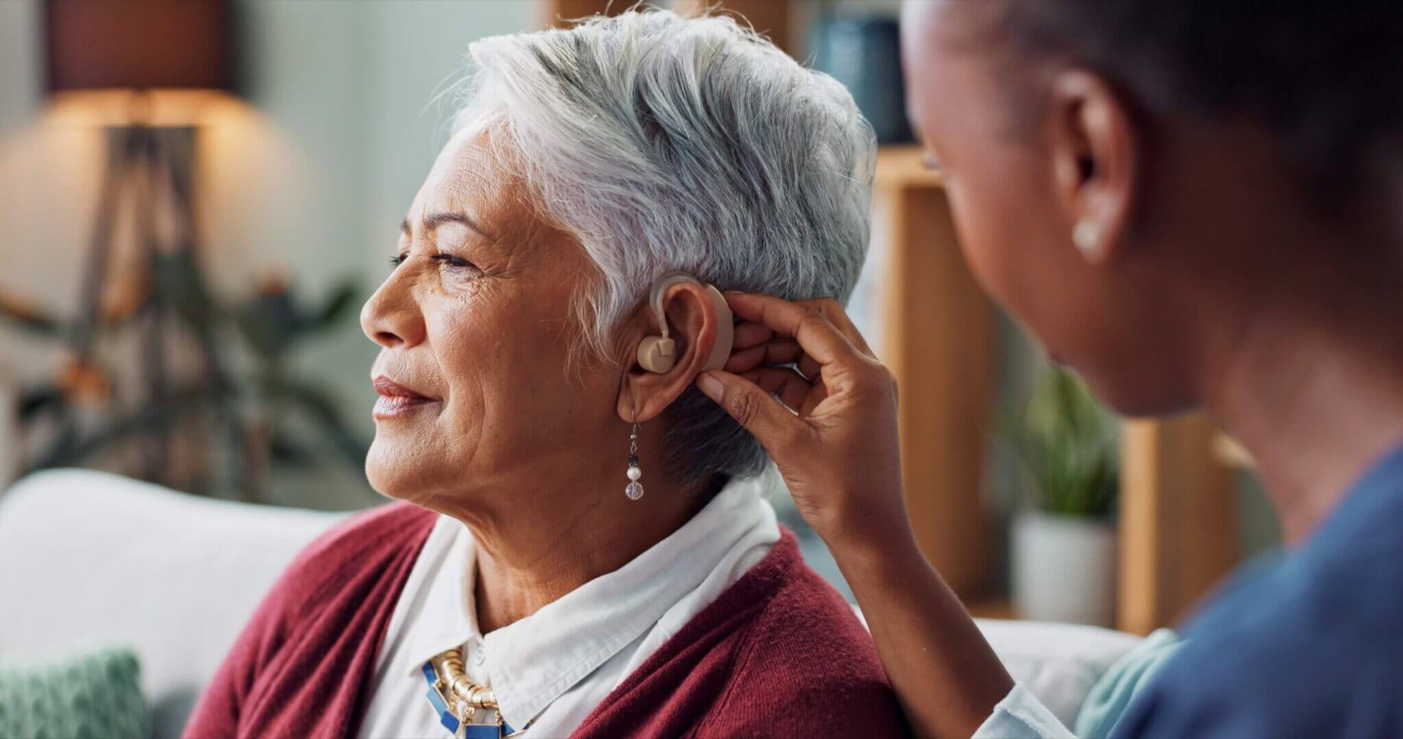 Woman having her hearing aid adjusted